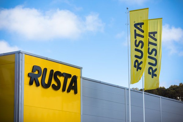 en byggnad med en skylt och två flaggor där det står Rusta