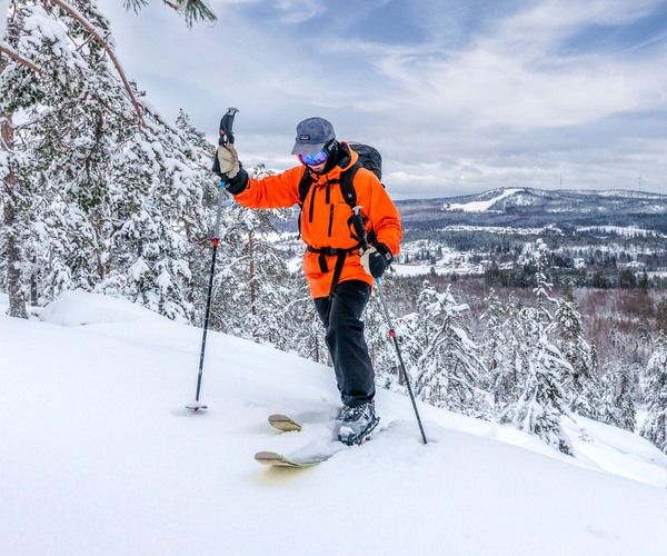 en skidåkare som kommer upp på ett snöklätt berg