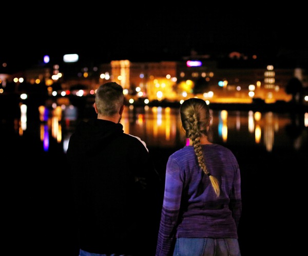 två personer sedda bakifrån i en stad i kvällsljus