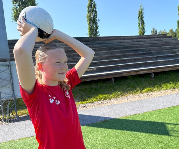 en flicka kastar ett inkast i fotboll