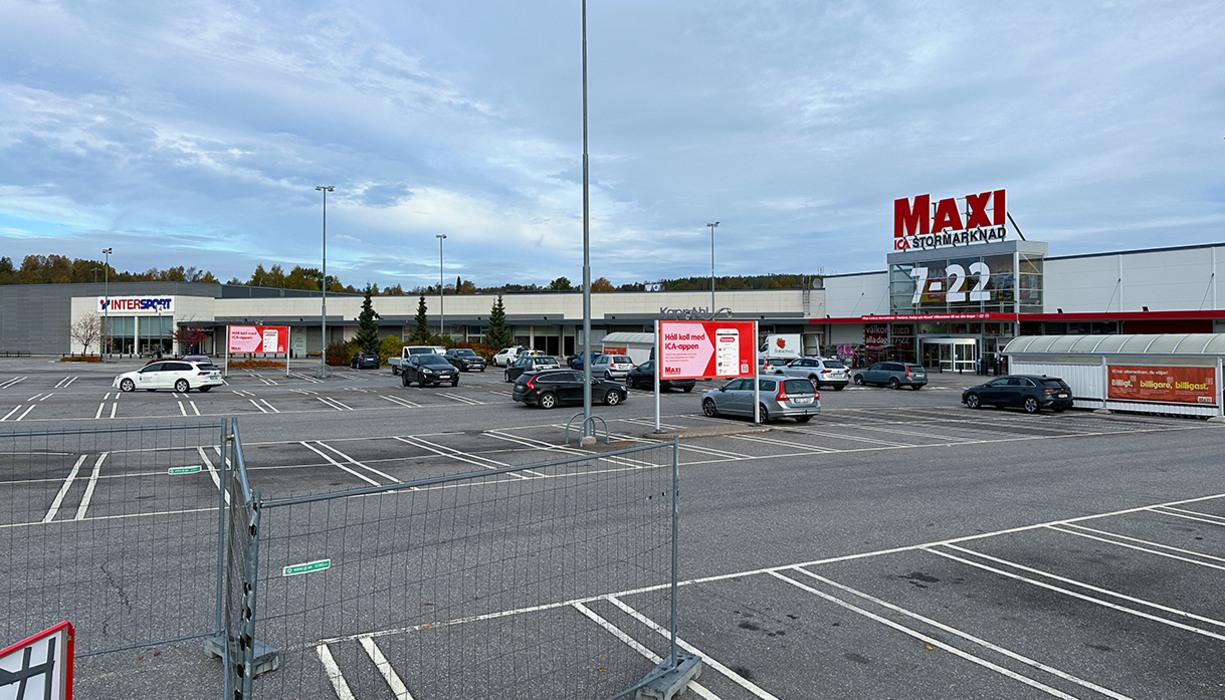 en stor parkeringsplats vid en stor byggnad som rymmer Ica Maxi och Intersport