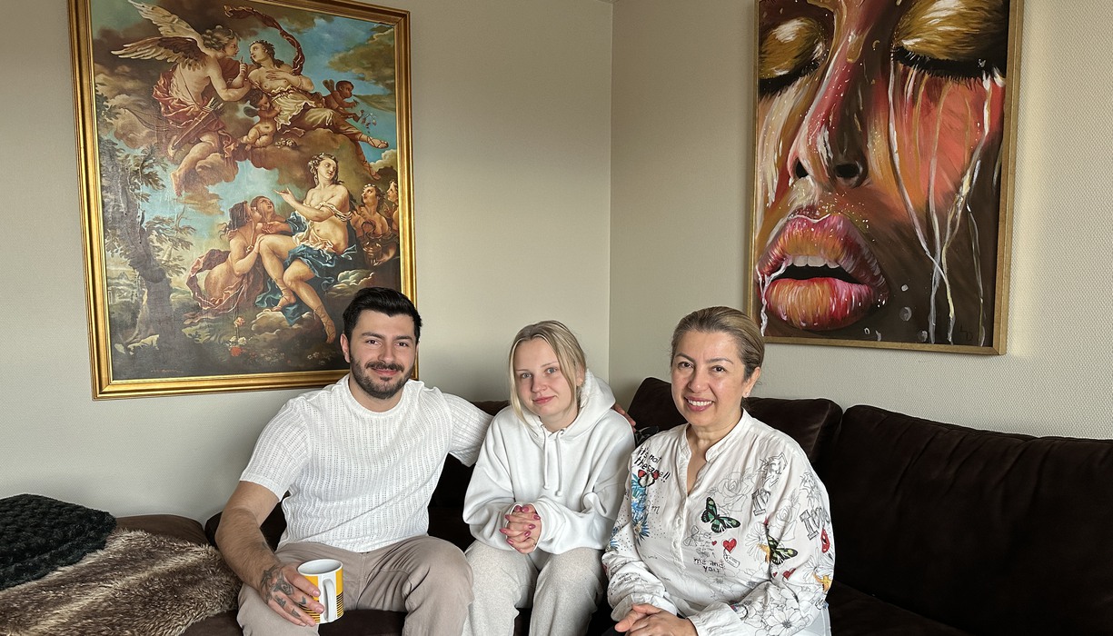 tre personer sitter i en brun hörnsoffa