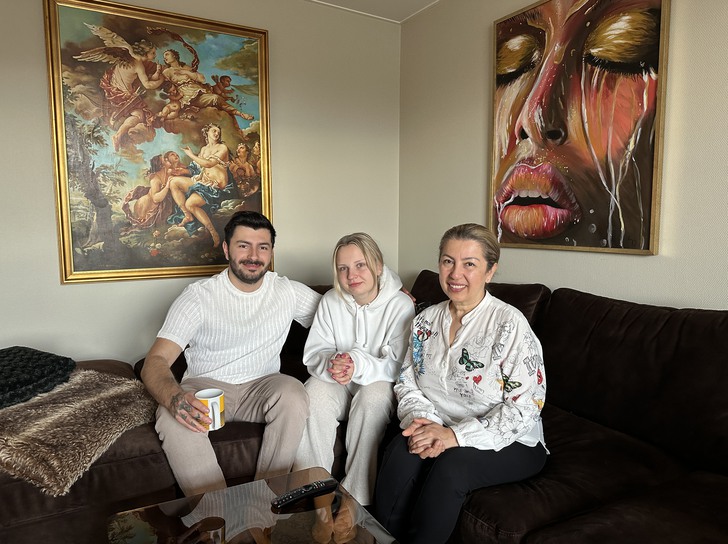 tre personer sitter i en brun hörnsoffa