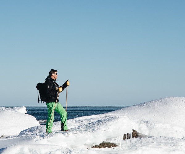 en person åker skidor på en snöformation nära vattnet