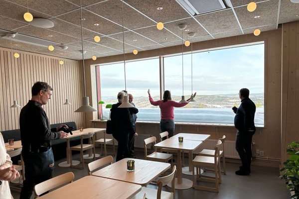 fler apersoner står i ett rum med fin utsikt.