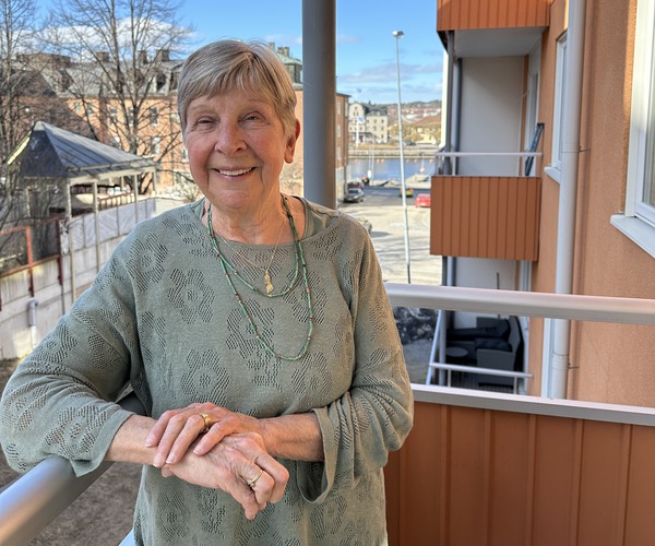 en äldre kvinna står på en balkong