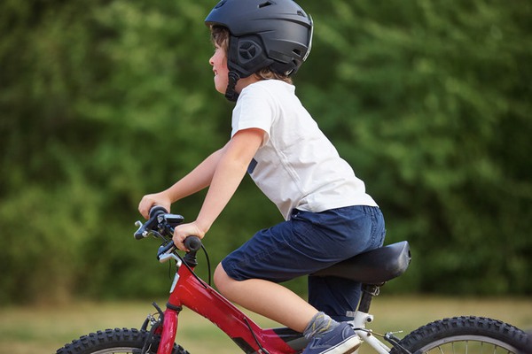 ett barn med hjälm som cyklar